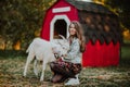 Portrait of teen girl with long hair hugging with a white goat in a farm. Copy space Royalty Free Stock Photo