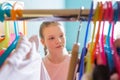 Portrait of a pretty teen girl looking through the wardrobe with clothing Royalty Free Stock Photo