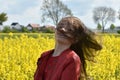 Girl in canola field with wild flying hair Royalty Free Stock Photo