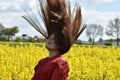 Girl in canola field with wild flying hair Royalty Free Stock Photo