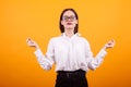 Portrait pretty teenage girl meditate in studio over yellow background Royalty Free Stock Photo