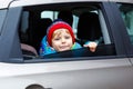 Portrait of pretty toddler boy sitting in car seat. Child transportation safety. Cute healthy kid boy looking happy Royalty Free Stock Photo