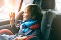 Portrait of pretty toddler boy sitting in car seat. Child transportation safety