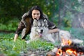 Portrait of a pretty white woman with an Alaskan Malamute dog by the fire