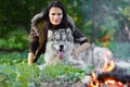 Portrait of a pretty woman with an Alaskan Malamute dog by the fire