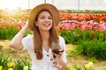 Portrait of pretty woman drinking glass of red wine over flowered background looking to the side with happy face smiling Royalty Free Stock Photo