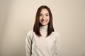 Portrait of pretty woman with gorgeous chestnut hair and charming smile on light background