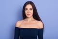 Portrait of pretty woman looking at camera with charming smile, happy girl wearing dark blue dress with bare shoulders, slim Royalty Free Stock Photo