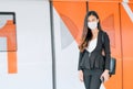 Portrait of pretty woman with mask stand in front of door of sky train on the platform during coronavirus pandemic in city Royalty Free Stock Photo