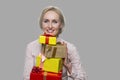 Portrait of pretty woman with pile of gift boxes.