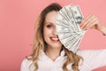 Portrait of pretty woman smiling and holding money fan isolated over pink background Royalty Free Stock Photo