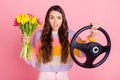Portrait of pretty worried nervous girl delivering bunch tulips driving invisible car order shop isolated over pink Royalty Free Stock Photo