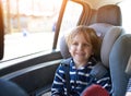 Portrait of pretty 6 year old boy sitting in car seat. Child transportation safety