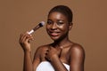 Portrait of pretty young african american woman holding blush makeup brush