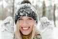 Portrait of pretty young blond woman, dressed warmly, with mittens. Beautiful girl having fun in the snow. Close-up view Royalty Free Stock Photo