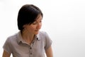 Portrait of a pretty young brunette woman looking down or watching something against a white wall Royalty Free Stock Photo