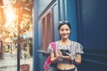 Portrait of pretty young hipster woman having fun in the city with camera taveling taking Royalty Free Stock Photo