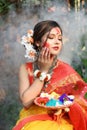 Portrait of pretty young indian girl wearing traditional saree and jewellery, holding powder colours in plate on the festival of Royalty Free Stock Photo