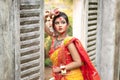 Portrait of pretty young indian girl wearing traditional saree and jewellery, playing with colors. Royalty Free Stock Photo