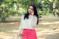 Portrait of pretty young Indian woman with long hair isolated over blured green trees park background talking chatting on phone Royalty Free Stock Photo