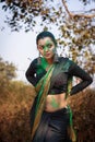 Portrait of a pretty young Indian woman wearing traditional saree and jewellery with spring festive make-up celebrating festival