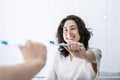 portrait of a pretty young latin girl holding a toothbrush and smiling in front of the mirror. Royalty Free Stock Photo
