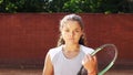 Portrait of pretty young tennis playgirl with racket smiling and going at camera