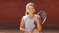 Portrait of pretty young tennis playgirl standing with racket.