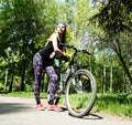 Portrait of pretty young woman with bicycle in a park - outdoor Royalty Free Stock Photo