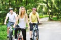 Portrait of pretty young woman with bicycle in a park with two m Royalty Free Stock Photo