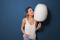 Portrait of pretty young woman with cotton candy on blue Royalty Free Stock Photo