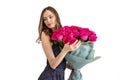 Portrait of a pretty young woman with curly hair in a black dress, holding a bouquet of roses, isolated on a white Royalty Free Stock Photo