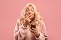 Portrait of pretty young woman eating chocolate cream from jar and enjoying sweet paste with closed eyes Royalty Free Stock Photo