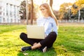 Portrait of a pretty young woman with glasses sitting on green g Royalty Free Stock Photo