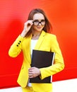 Portrait of pretty young woman in glasses, yellow suit