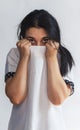 Portrait of a pretty young woman hiding her face under clothes. Attractive Muslim girl hiding face under clothes and looking Royalty Free Stock Photo