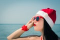 Portrait of a pretty young woman in Santa Claus hat and sunglasses Royalty Free Stock Photo