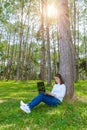 Portrait of pretty young woman sitting on green grass in park summer day while using laptop Royalty Free Stock Photo