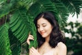 Portrait of pretty young woman standing near leaves outdoors Royalty Free Stock Photo