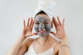 Portrait of pretty young woman wears beauty black clay mask on face isolated on white Royalty Free Stock Photo