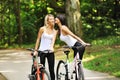 Portrait of pretty young women with bicycle in a park Royalty Free Stock Photo