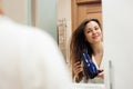 Portrait of prety young woman using hairdryer. Royalty Free Stock Photo