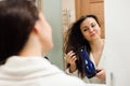 Portrait of prety young woman using hairdryer. Royalty Free Stock Photo