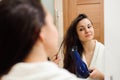 Portrait of prety young woman using hairdryer.