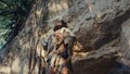 Portrait of Primeval Caveman Wearing Animal Skin Does Aggressive Chest Beating and Screaming, Defe Royalty Free Stock Photo