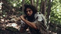 Portrait of Primeval Caveman Wearing Animal Skin and Fur Hunting with a Stone Tipped Spear in the