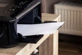 A portrait of a printer with an empty white piece of paper in its printed output tray. The blank page can be used to display some Royalty Free Stock Photo