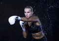 Portrait of Professional Active Female Boxer Posing with White Gloves in Aqua Studio Against Black Background