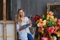 Portrait of a professional artist painting on canvas in the studio. A female artist draws in the workplace. A blonde girl in a