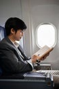 Portrait, A professional Asian businessman is on the flight, reading on his notebook Royalty Free Stock Photo